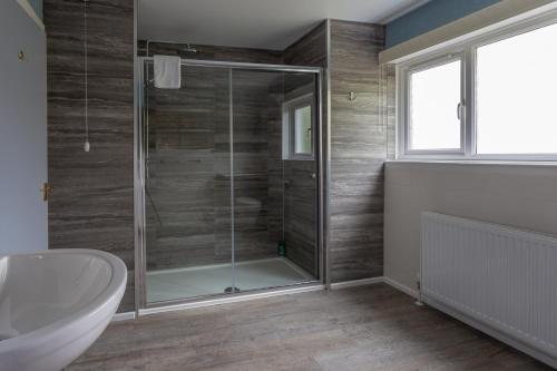 a bathroom with a shower with a sink and a toilet at Braeburn Guesthouse in Fort William