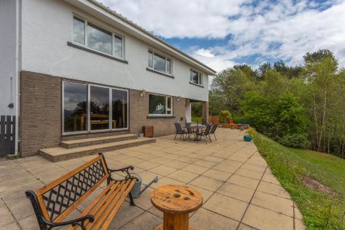 a patio with two benches and a table in front of a house at Braeburn Guesthouse in Fort William