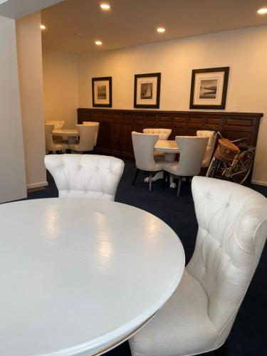 a waiting room with a white table and chairs at The Argus Hotel & Cocktail Lounge in Albany