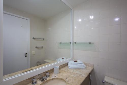 baño con lavabo y espejo grande en Mc Flats Leblon Inn, en Río de Janeiro