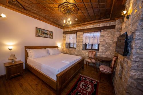 a bedroom with a bed and a stone wall at Berati Castle Hotel in Berat