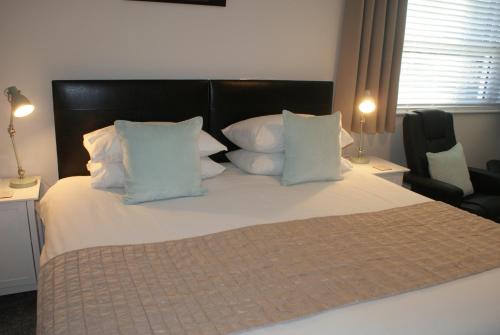 a bedroom with a large bed with white pillows at Tirah Guest House in Aldeburgh