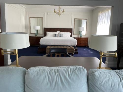 a bedroom with a bed and two lamps and a couch at The Argus Hotel & Cocktail Lounge in Albany