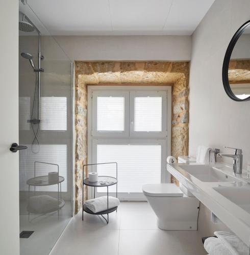 a bathroom with a sink and a toilet and a window at HOTEL ARRiZUL BEACH in Donostia-San Sebastián