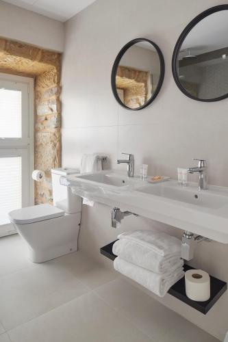 a white bathroom with a sink and a toilet at HOTEL ARRiZUL BEACH in Donostia-San Sebastián