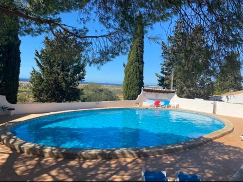 a large blue swimming pool in a yard at Casa Aleg in Albufeira