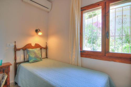 Schlafzimmer mit einem Bett und einem Fenster in der Unterkunft Villa con piscina y vistas al mar - Mar 27 H in Calpe