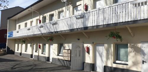 a white building with a balcony on top of it at Apartmenthaus beim LKH Graz in Graz