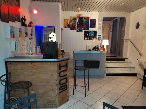 a bar in a restaurant with a counter and stools at Hôtel Confort 09 ou HC-09 in Tarascon-sur-Ariège