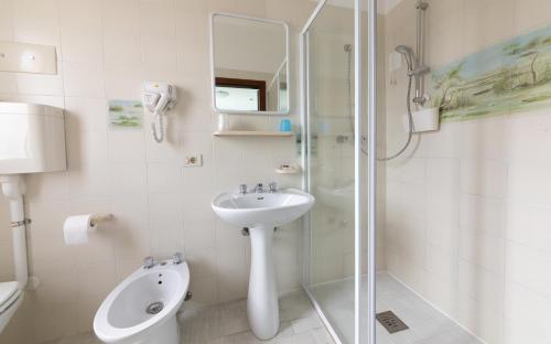 a bathroom with a shower and a sink and a toilet at Hotel Paolina in Lido di Jesolo