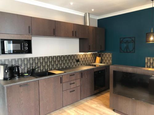 a kitchen with wooden cabinets and a counter top at la maison du philosophe in Amboise