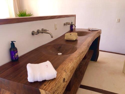 a bathroom with a wooden counter with a sink at Hotel Nude Zipolite & beach club in Zipolite