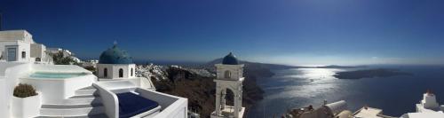 a view of the ocean and buildings on a cliff at Altana Heritage Suites in Imerovigli