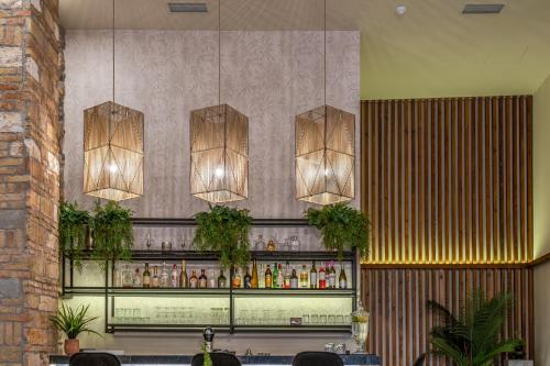 un bar con tres luces colgando de una pared en Philia Boutique Hotel en Athens