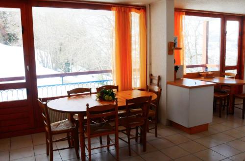 Les Arcs 1600, Plan Devin 2 في آرك 1600: غرفة طعام مع طاولة وكراسي ونوافذ