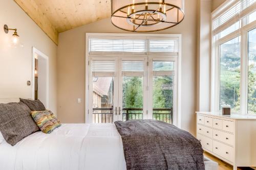 a bedroom with a white bed and a window at Boulders Way - 15 in Telluride