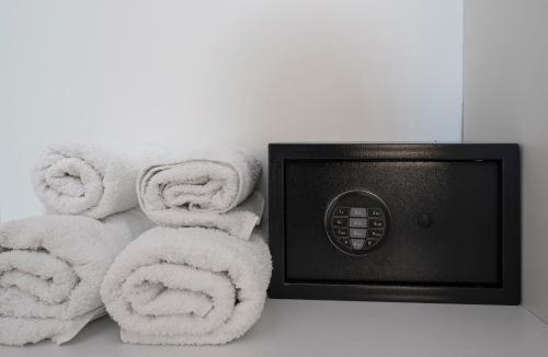 uma pilha de toalhas sentadas ao lado de um micro-ondas em Sea Path Apartment em PalaiónTsiflíkion