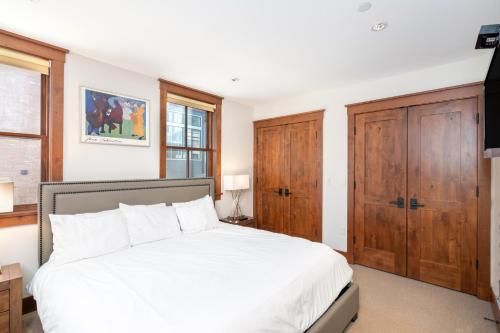 a bedroom with a white bed and wooden cabinets at Ballard North in Telluride