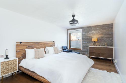a bedroom with a large bed and a brick wall at Colorado Ave East 101 - Ski Loft House in Telluride