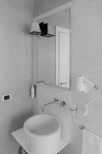 a white bathroom with a sink and a mirror at Hotel Clitunno in Spoleto