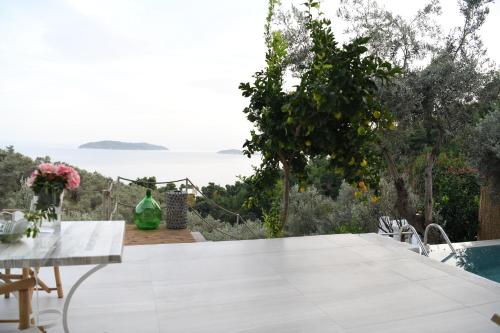 a white table with a view of the ocean at The Hidden Gem in Skiathos Town