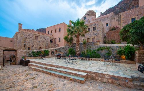 a building with stairs and tables and chairs at Guesthouse Kellia in Monemvasia