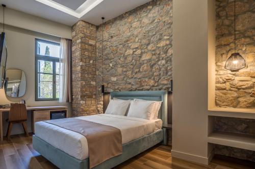 a bedroom with a stone wall and a bed at Philia Boutique Hotel in Athens