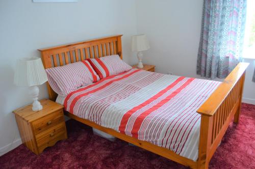 a bedroom with a wooden bed with two pillows at Kirk View holiday apartment in Kirkcaldy