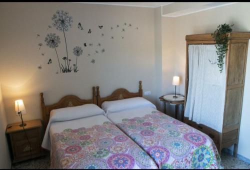 拉瓦納爾德爾卡米諾的住宿－LA CASONA DE RABANAL，卧室配有一张墙上鲜花的床