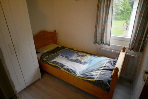 a small bed in a room with a window at Vakantie Zuid Limburg in Simpelveld