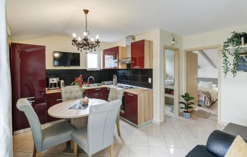 a kitchen with a table, chairs and a refrigerator at Apartments Prpic in Senj