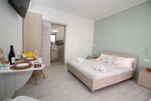 a bedroom with a bed and a table and a desk at Monolocale in centro a due passi dal mare in San Vito lo Capo