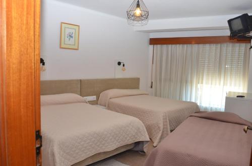 um quarto de hospital com duas camas e uma televisão em Alojamento Local Manuel da Parreira na Figueira da Foz