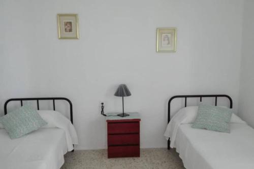 1 dormitorio con 2 camas y una lámpara en un tocador en Casita Abuela Rosa, en Sabinosa