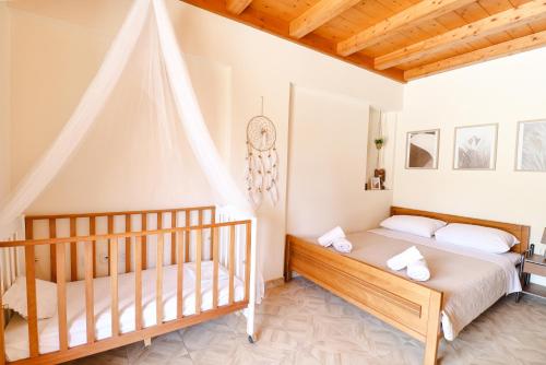 a bedroom with two beds and a crib at Mansion on the Hill by CorfuEscapes in Virós