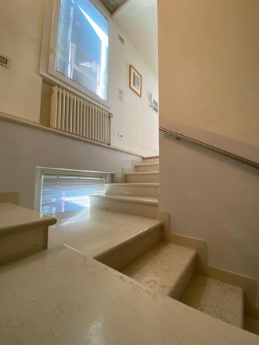 an empty room with stairs and a window at Appartamenti Mavino in Sirmione