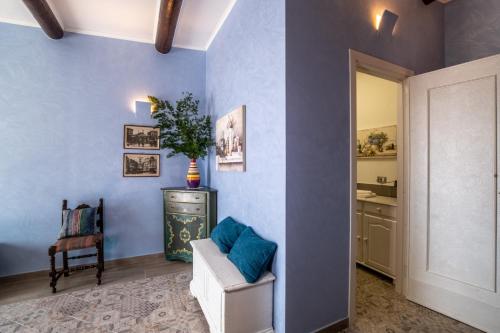a living room with blue walls and a white chair at Casa Viva in Colli di Fontanelle