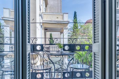 a balcony with a table and chairs and a window at Philia Boutique Hotel in Athens