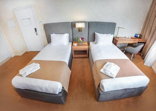 a hotel room with two beds and a desk at Meta Business Hotel By King David in Tbilisi City