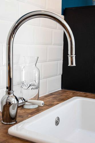 - un évier de cuisine avec un robinet à côté d'un comptoir dans l'établissement Appartement atypique au coeur des Alpes, à Barraux