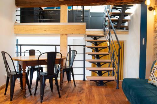 jadalnia ze stołem i spiralnymi schodami w obiekcie Appartement atypique au coeur des Alpes w mieście Barraux