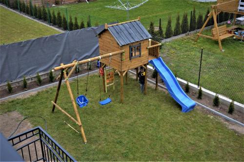 a small playground with a house and a slide at Pokoje U IGORA in Mikołajki