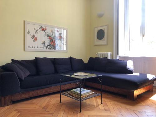 a black couch in a living room with a table at Sant'Ambrogio with charme in Milan