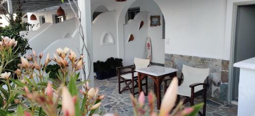 two chairs and a table on a patio with flowers at Anemomylos Houses in Koufonisia