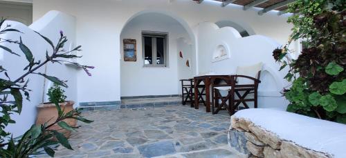 a courtyard with a table and chairs in a building at Anemomylos Houses in Koufonisia