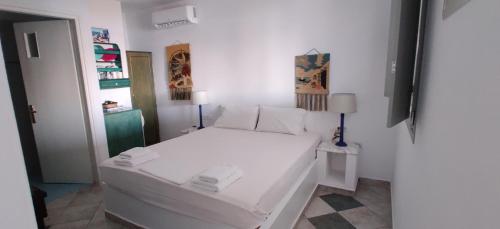 a bedroom with a white bed in a room at Anemomylos Houses in Koufonisia