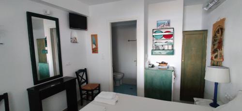 a room with a bed and a mirror and a bathroom at Anemomylos Houses in Koufonisia