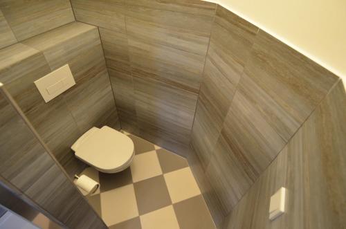 a small bathroom with a toilet and a checkered floor at KostelApartmány in Liberec