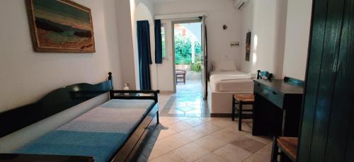 a room with a bed and a table and a bathroom at Anemomylos Houses in Koufonisia