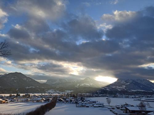 a snow covered city with mountains in the background at Haus Sonnenwinkl in Kössen